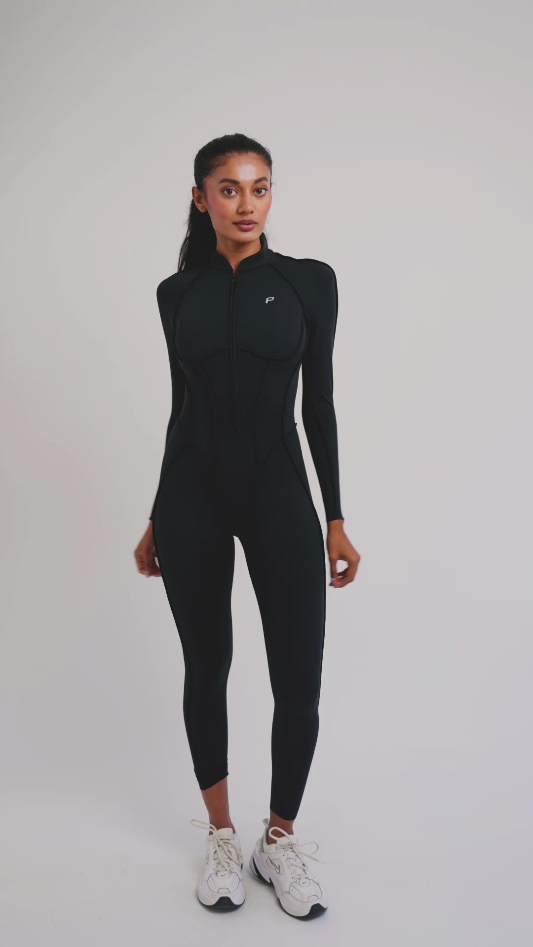 Load video: PilaNova Open-Back Catsuit – Contouring Seam Fit – Black
